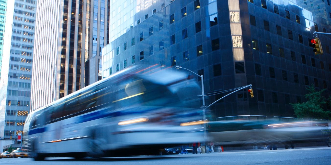 Blurred bus in downtown Canadian city, showcasing active public transit for comparing Vancouver and Toronto