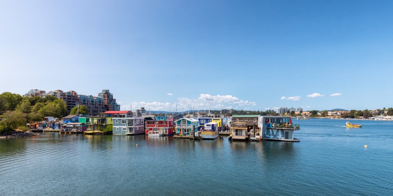 Colorful houseboats on the waterfront in Victoria, BC, showcasing the blend of historical charm and modern living