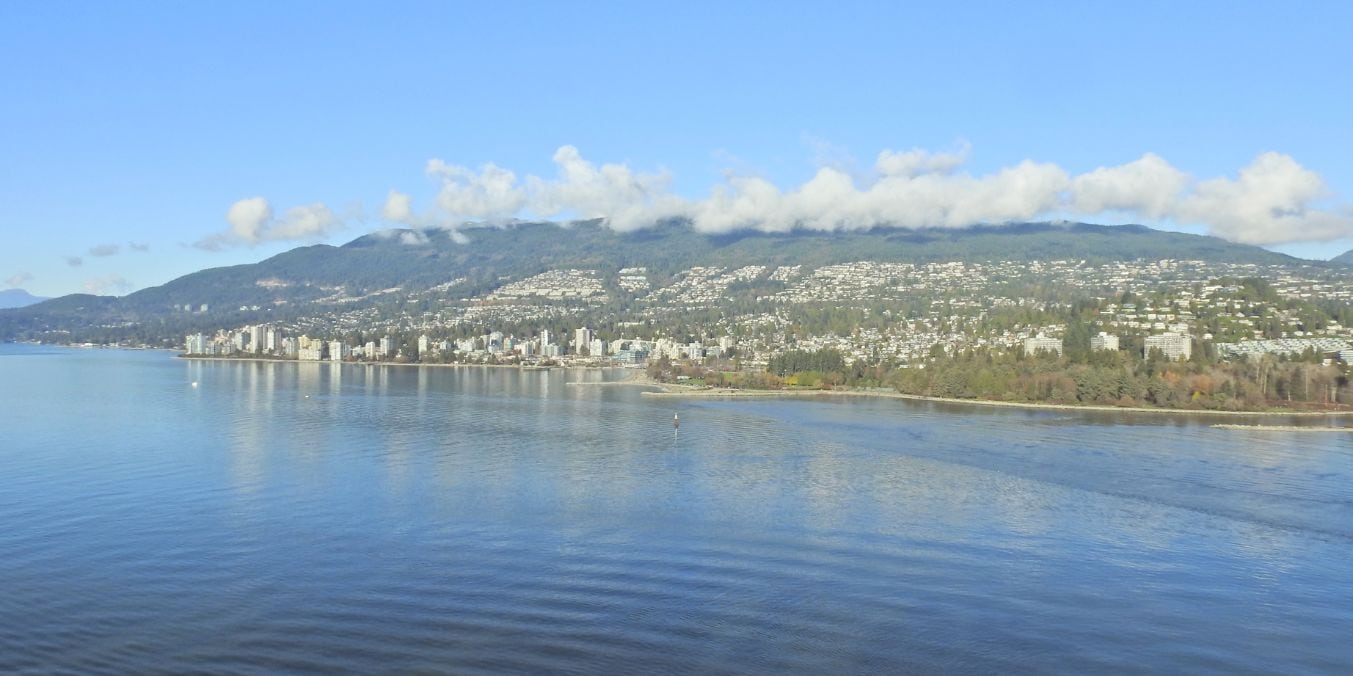 Panoramic view of the West End in Vancouver showcasing English Bay, urban skyline against a backdrop of forested hills, embodying the cultural diversity and natural beauty of one of the best places to live in Vancouver.