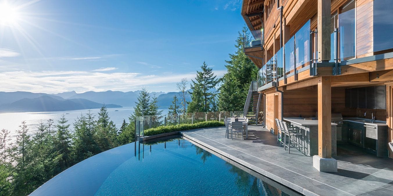 Luxurious home in West Vancouver with an infinity pool overlooking the ocean and mountainous landscape, epitomizing the exclusive and scenic living that makes it one of the best places to live in Vancouver