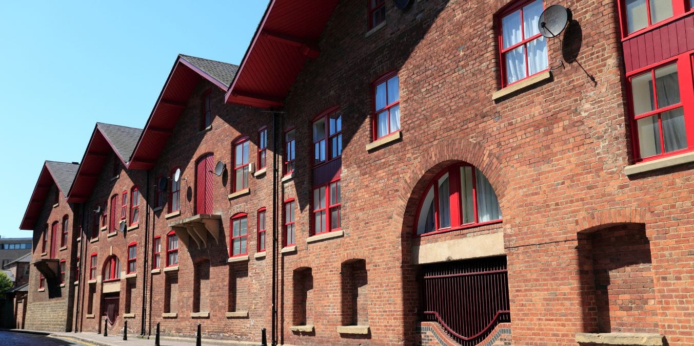 Restored historic warehouses in Yaletown, Vancouver, featuring red brick facades and bold red accents, symbolizing the neighborhood's trendy transformation and status as one of the best places to live in Vancouver