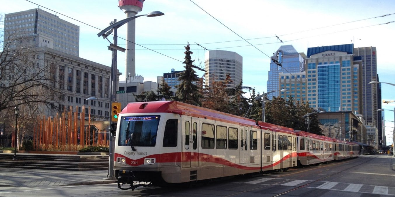 Calgary CTrain with city skyline, representing public transportation and infrastructure in Calgary