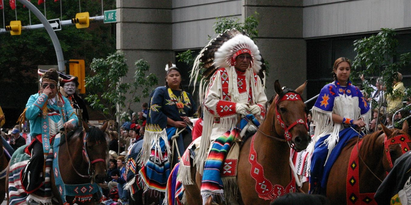 A scenic view of native people riding horses, participating the cultural and community life in the Calgary vs Winnipeg.