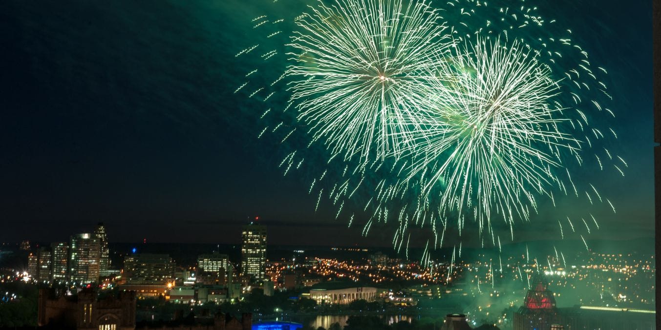 Fireworks over a city skyline, illustrating the vibrant cultural scene and entertainment options in Edmonton vs Vancouver.