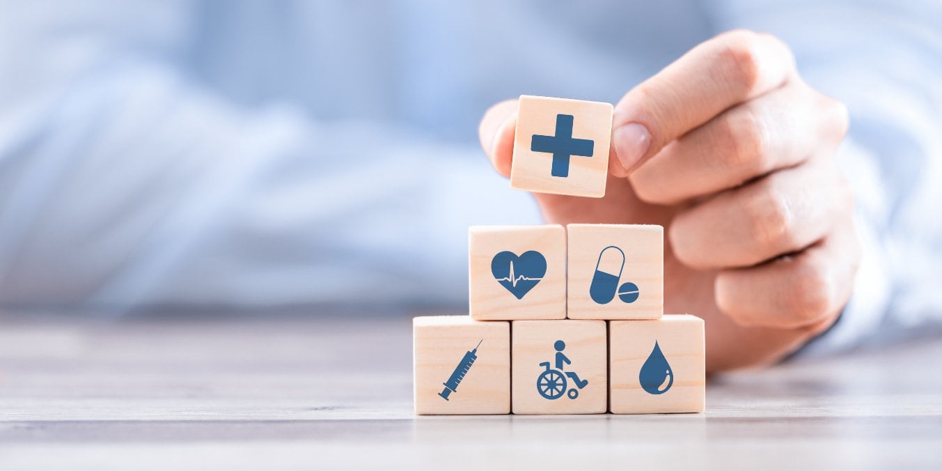 Hand arranging healthcare icons on wooden blocks in Edmonton