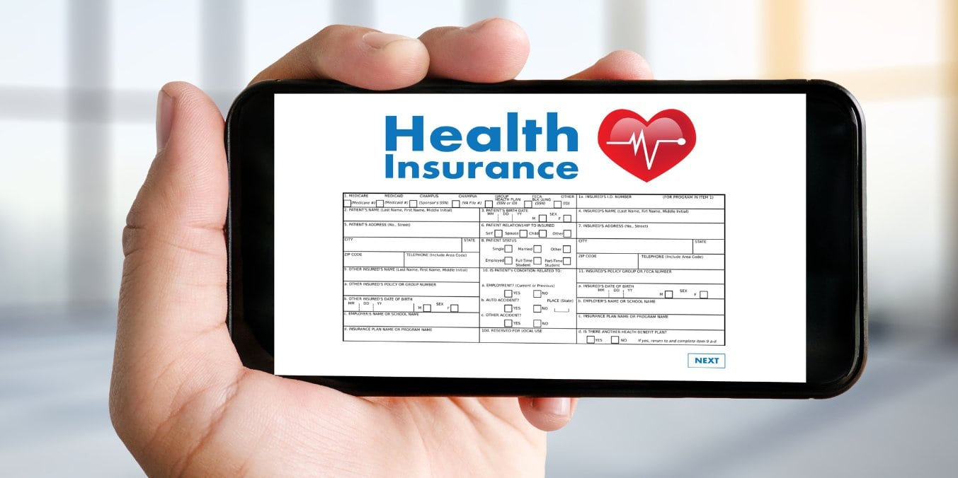 Person holding a phone displaying health insurance form, representing healthcare costs in Edmonton