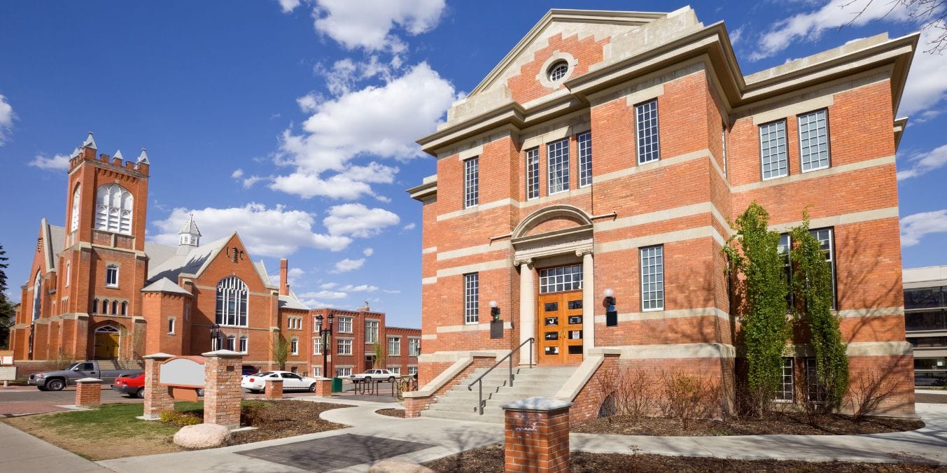 Historic red brick buildings with large windows and ornate details in Strathcona, Edmonton, highlighting as one of the best neighborhoods.