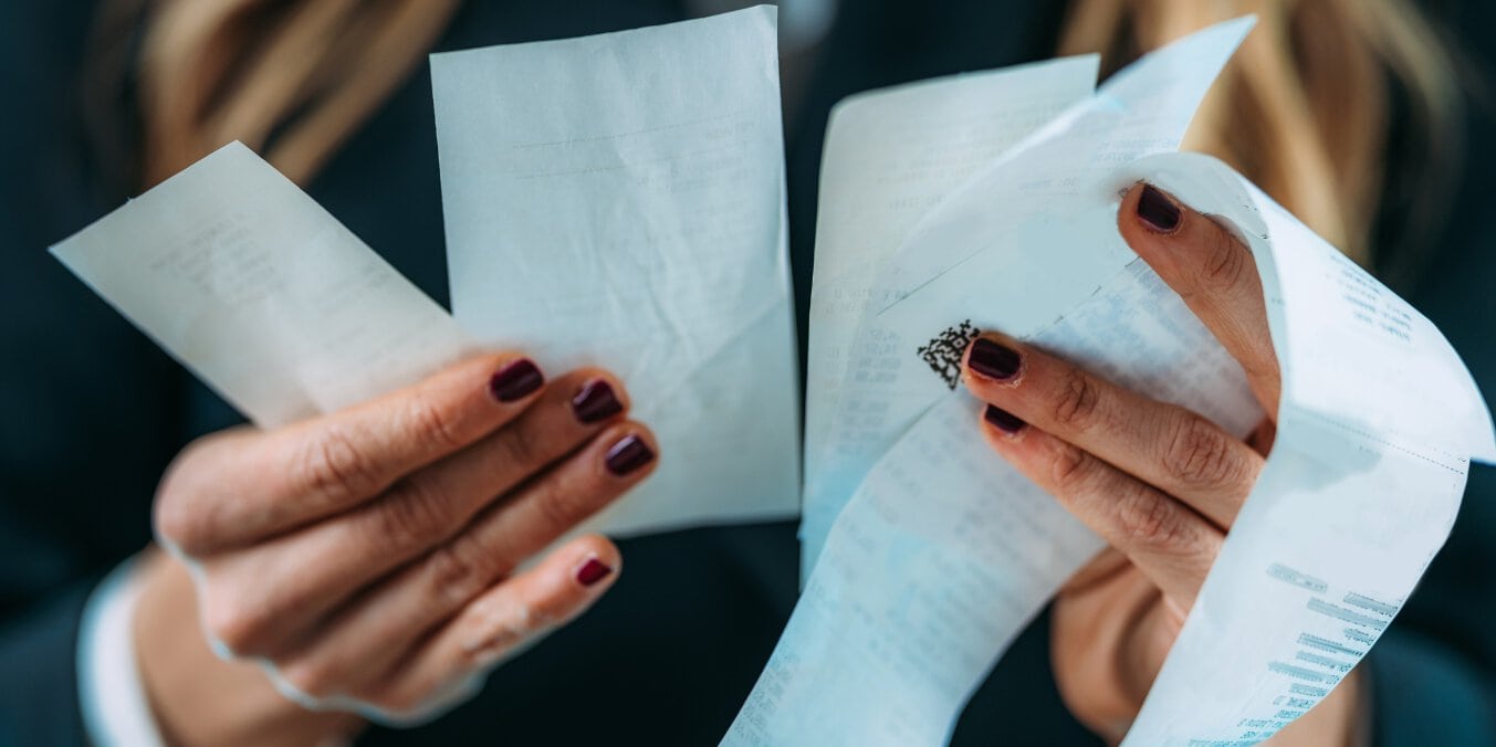 Person holding receipts comparing cost of living in Ottawa and Calgary