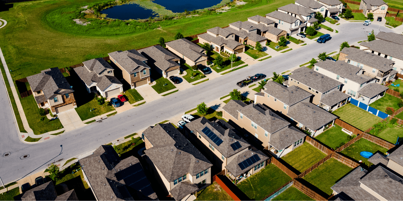 Aerial view of a suburban neighborhood with rows of houses and green lawns, illustrating the housing market and real estate options when comparing living in Calgary vs Toronto.