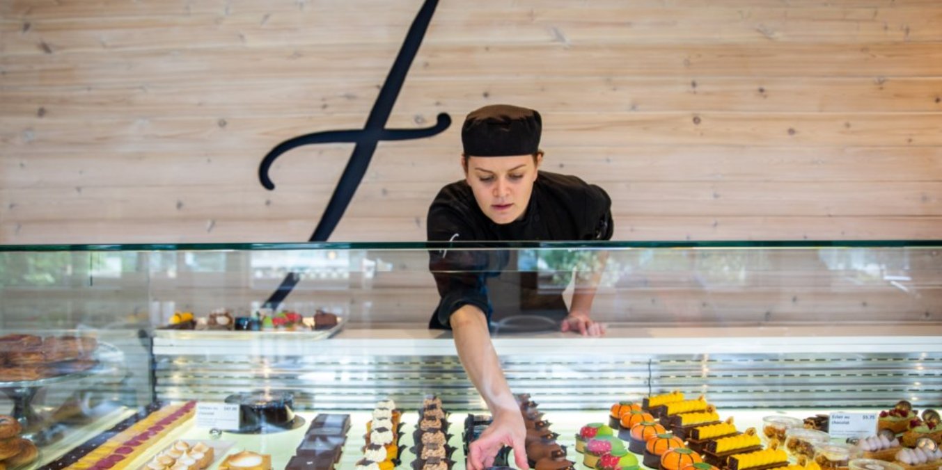 Pastry chef at Le Fournil Bakery displaying French pastries for the best breakfast in Canmore