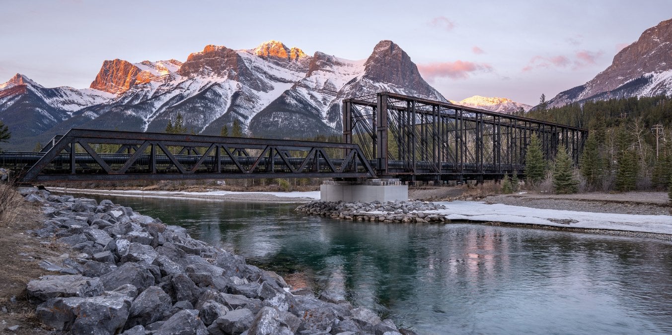 Scenic Canmore with a bridge and mountain backdrop, emphasizing why Canmore is the best place to live in Alberta