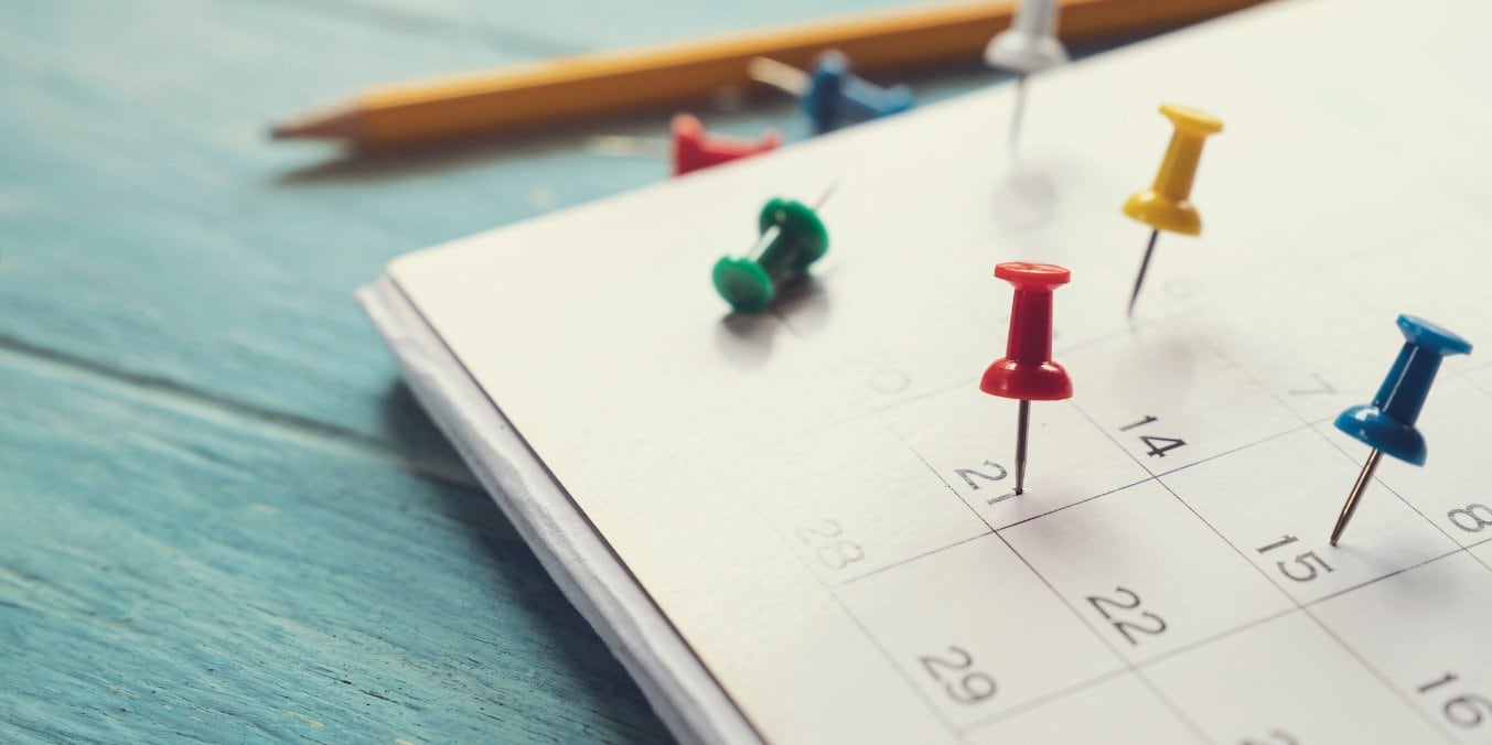 Calendar with push pins used for planning your move to Calgary from Vancouver