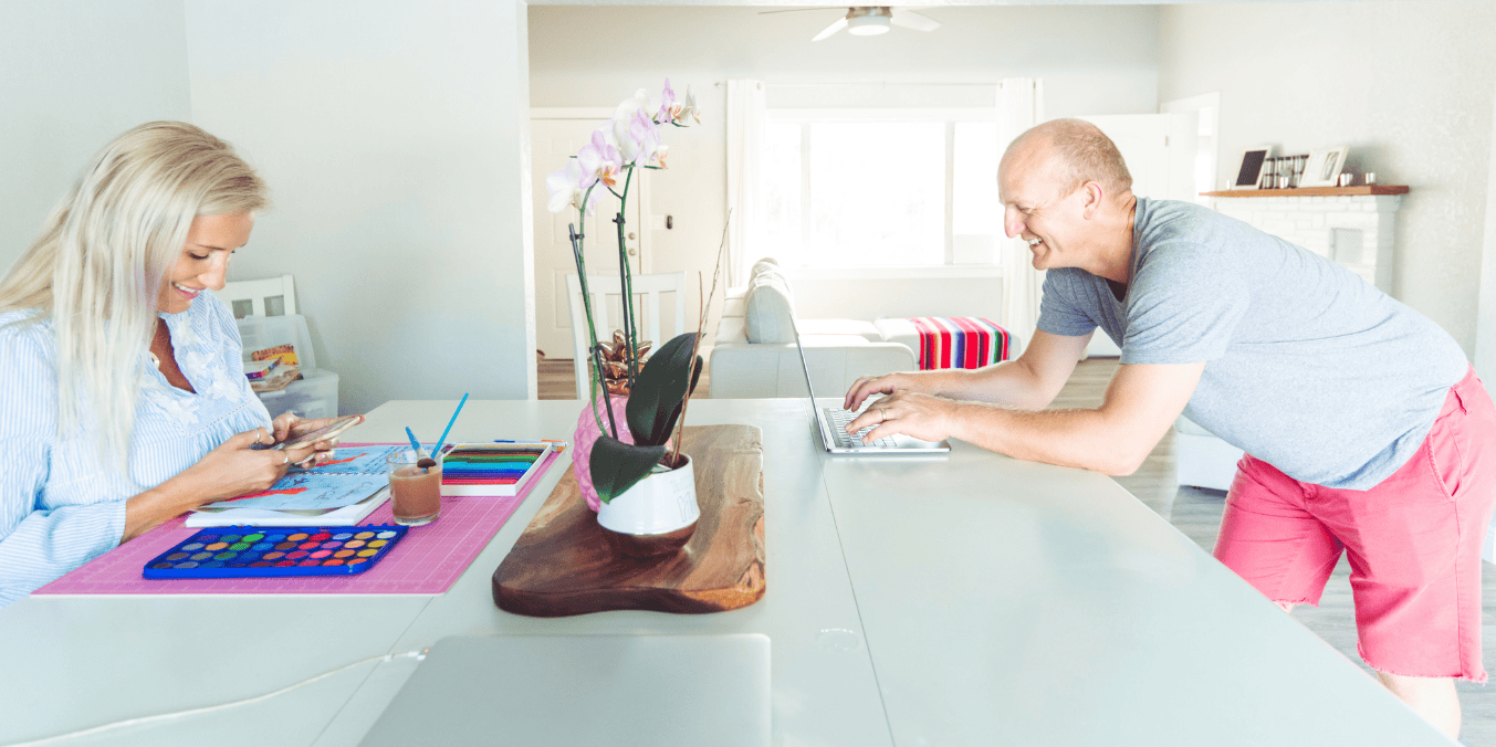 A couple working from home, with the woman painting and the man using a laptop, illustrating a shared space while discussing SOWP (Spousal Open Work Permit) options