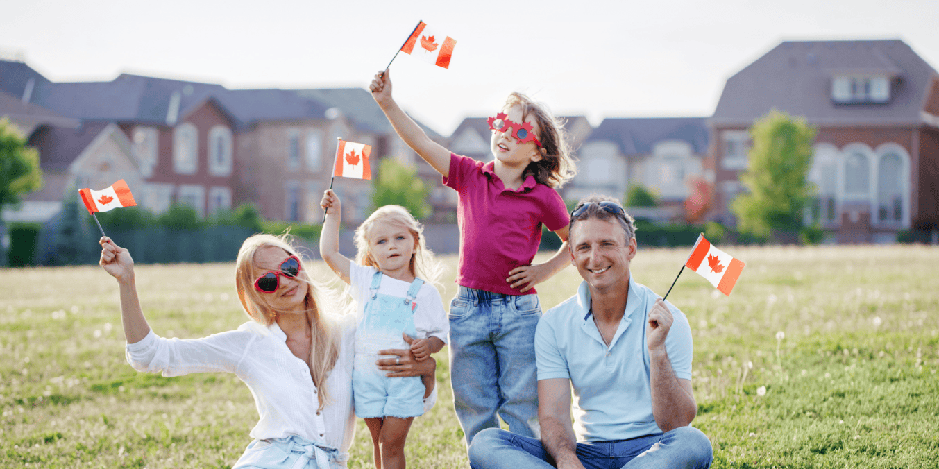 A happy family celebrates outdoors, waving Canadian flags. Discover the benefits of marrying a Canadian citizen and starting a life in Canada.