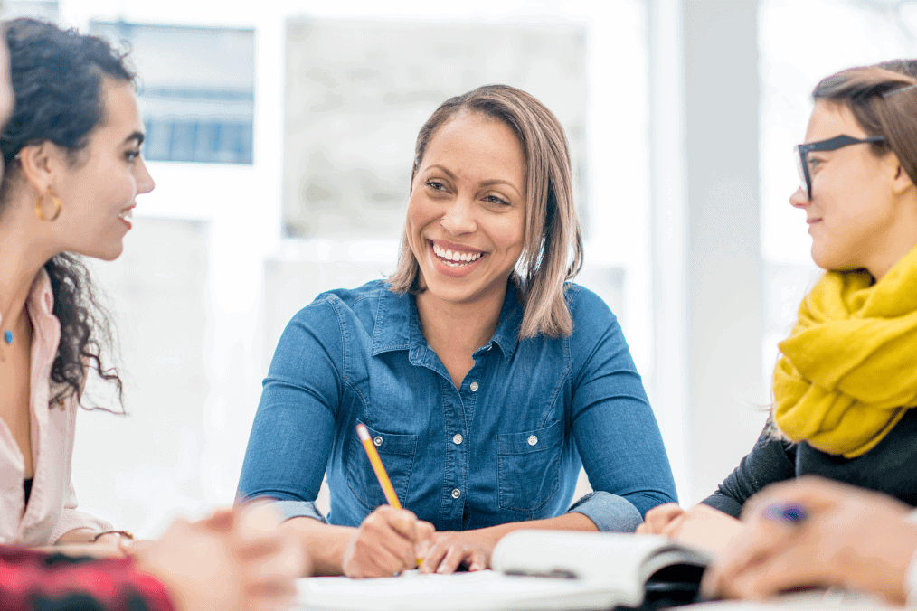 A diverse group of professionals engaged in a discussion about the recent PNP draw in Canada, sharing insights and strategies for immigration and permanent residency applications in a collaborative, bright office setting.