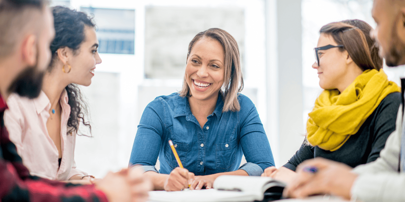 A diverse group of professionals engaged in a discussion about the recent PNP draw in Canada, sharing insights and strategies for immigration and permanent residency applications in a collaborative, bright office setting.