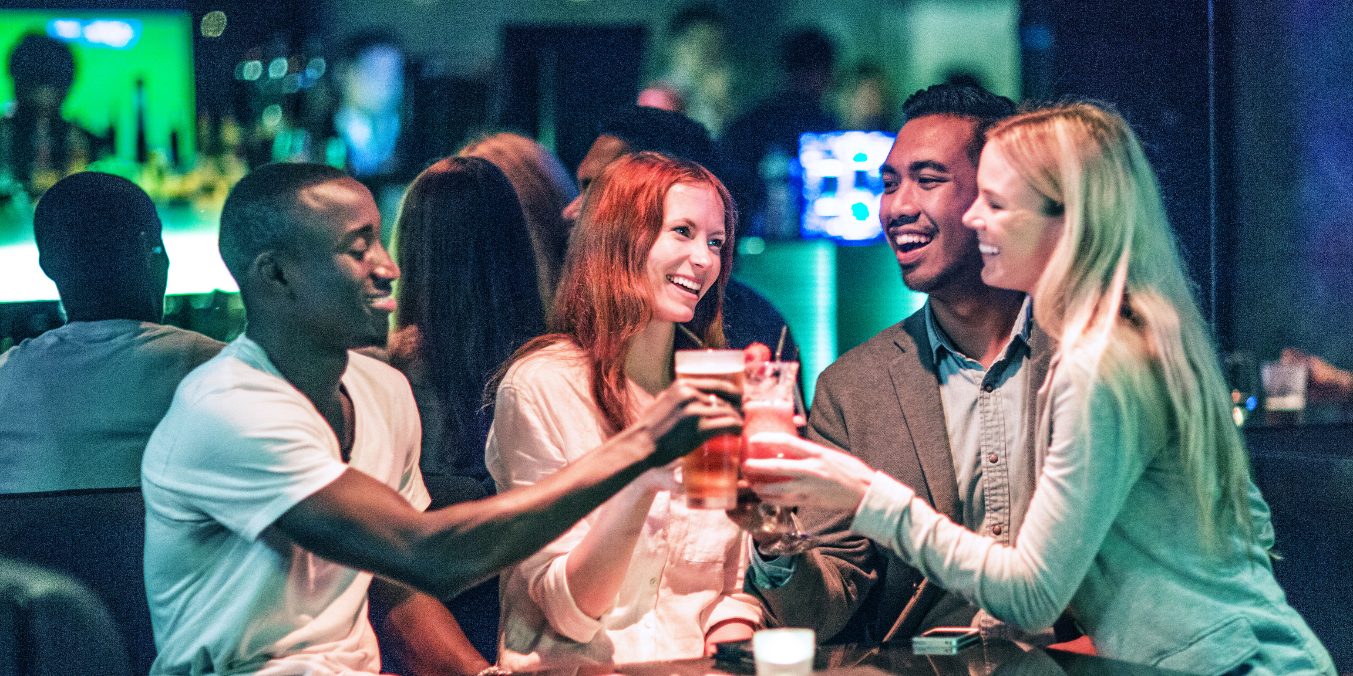 Friends enjoying Canmore nightlife at a lively bar with drinks and great company.