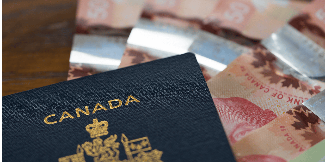 Close-up of a Canadian passport placed on a table with Canadian dollar bills in the background, symbolizing financial aspects of the Express Entry draw process for immigration.