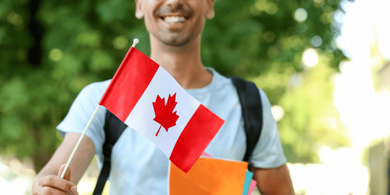 A smiling student holds a Canadian flag while carrying books, symbolizing their aspiration to obtain a study permit and pursue education in Canada.