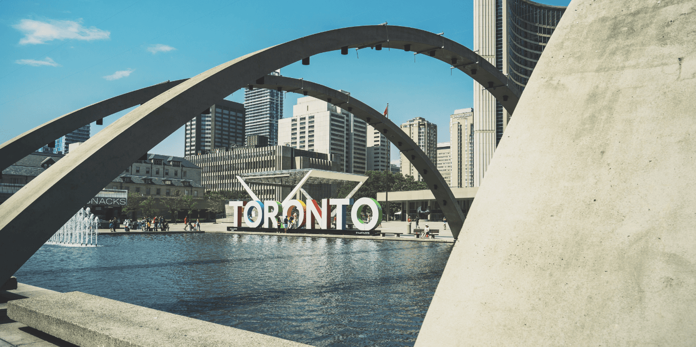 Daytime view of Nathan Phillips Square and the Toronto sign, a popular spot for visitors considering how much bank balance is required for Canada immigration.