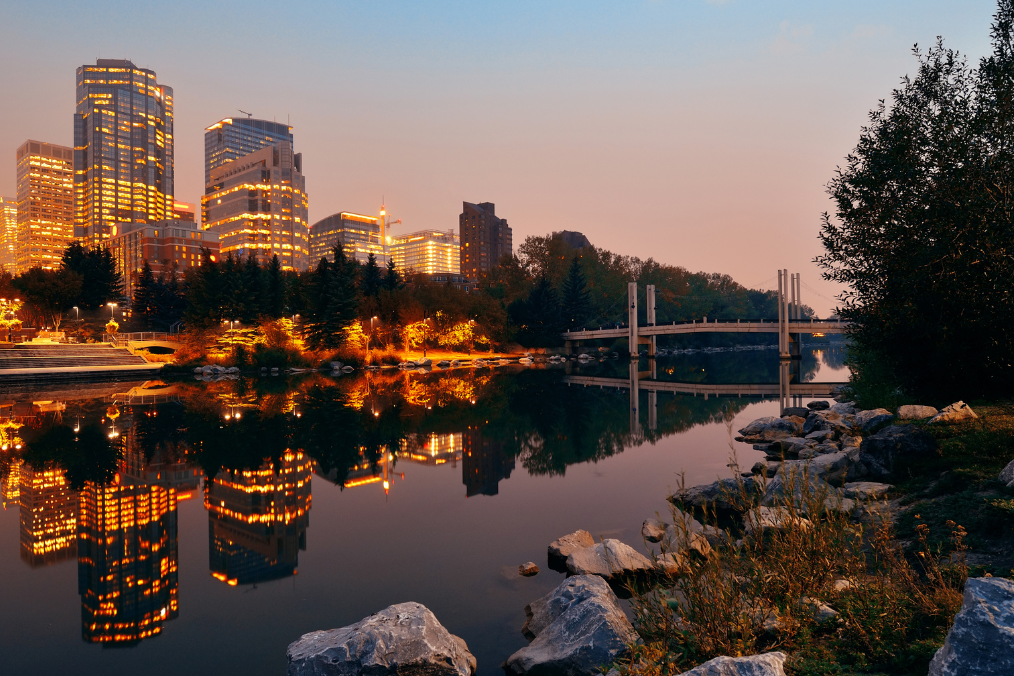 A beautiful evening view of downtown Calgary, highlighting its vibrant cityscape and reflecting skyline, making many wonder, 