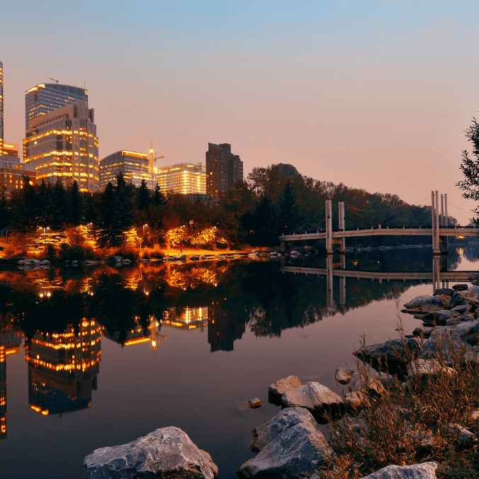 A beautiful evening view of downtown Calgary, highlighting its vibrant cityscape and reflecting skyline, making many wonder, 