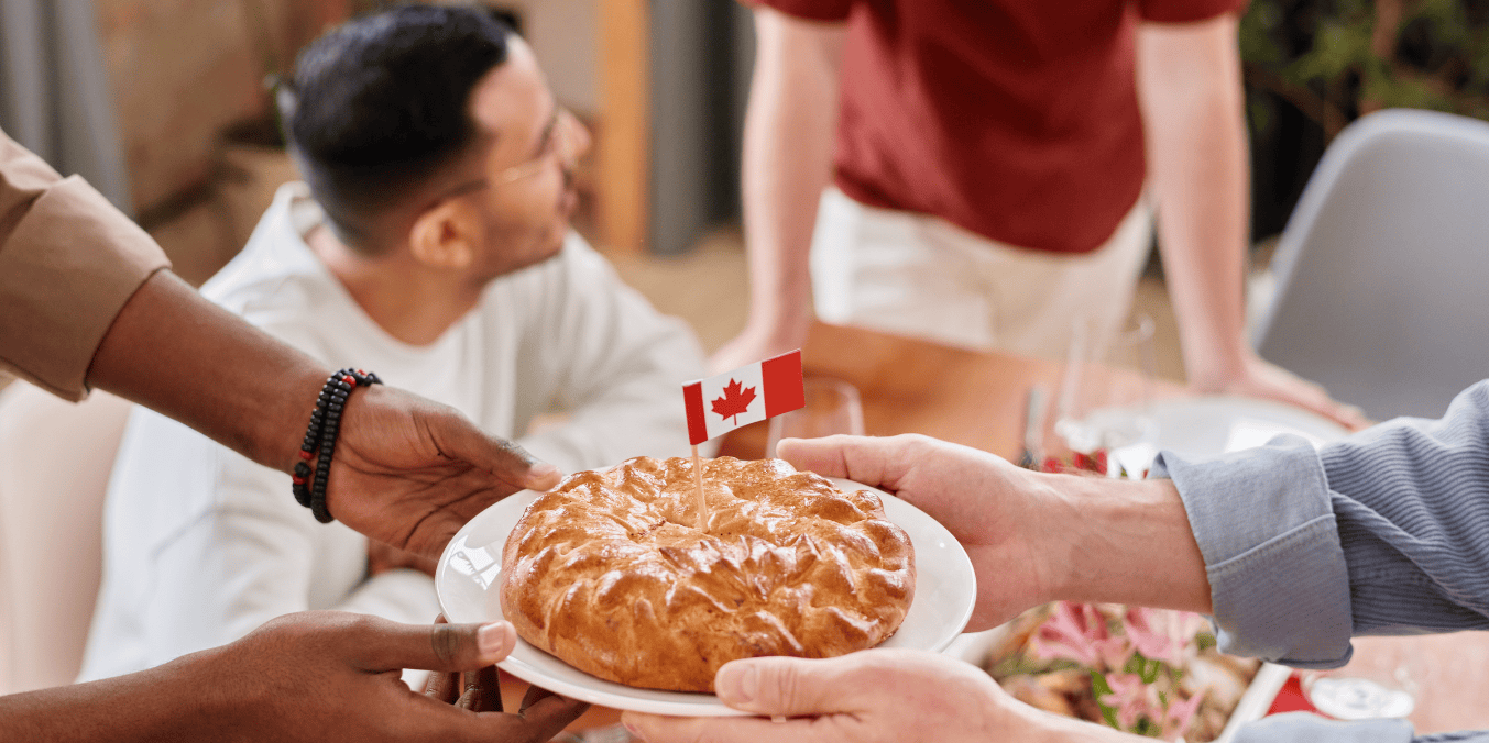 Is Calgary immigrant friendly? A welcoming gathering where people share a meal featuring a Canadian flag, symbolizing Calgary's inclusive and supportive environment for newcomers.