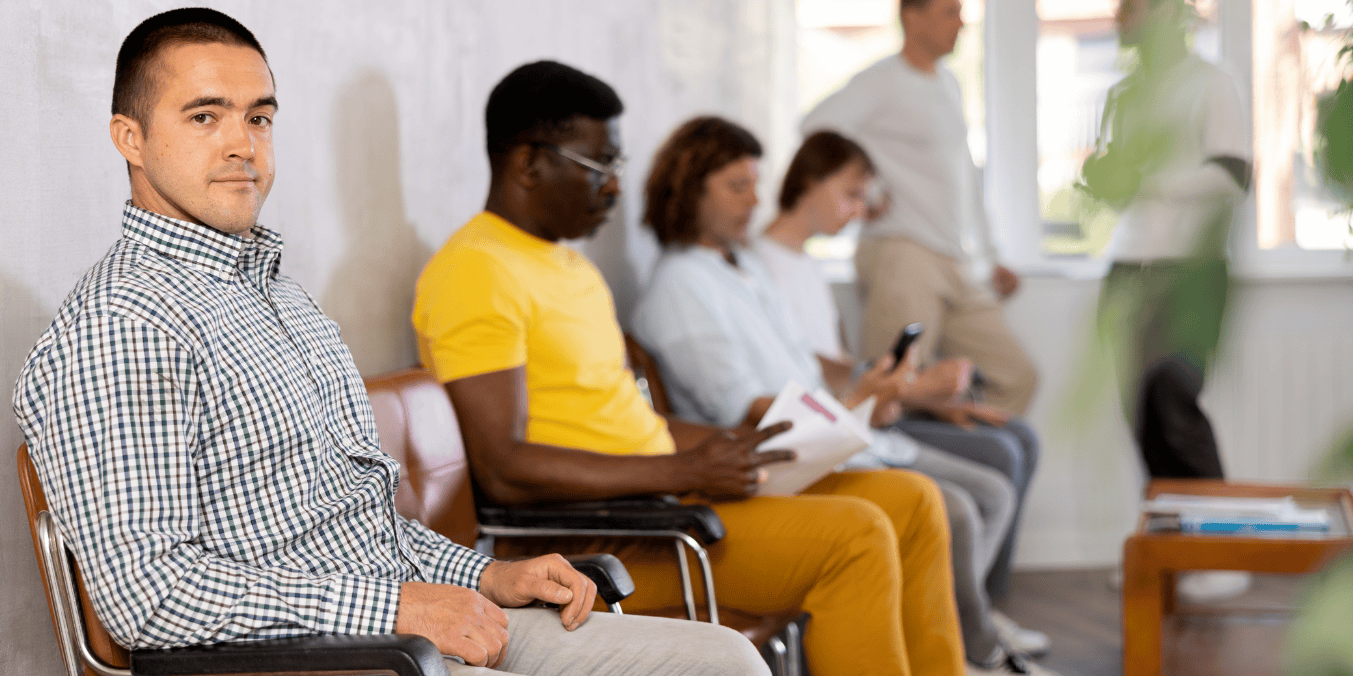 Is Calgary immigrant friendly? A diverse group of people waiting together, reflecting the city's inclusive approach and support systems for newcomers.