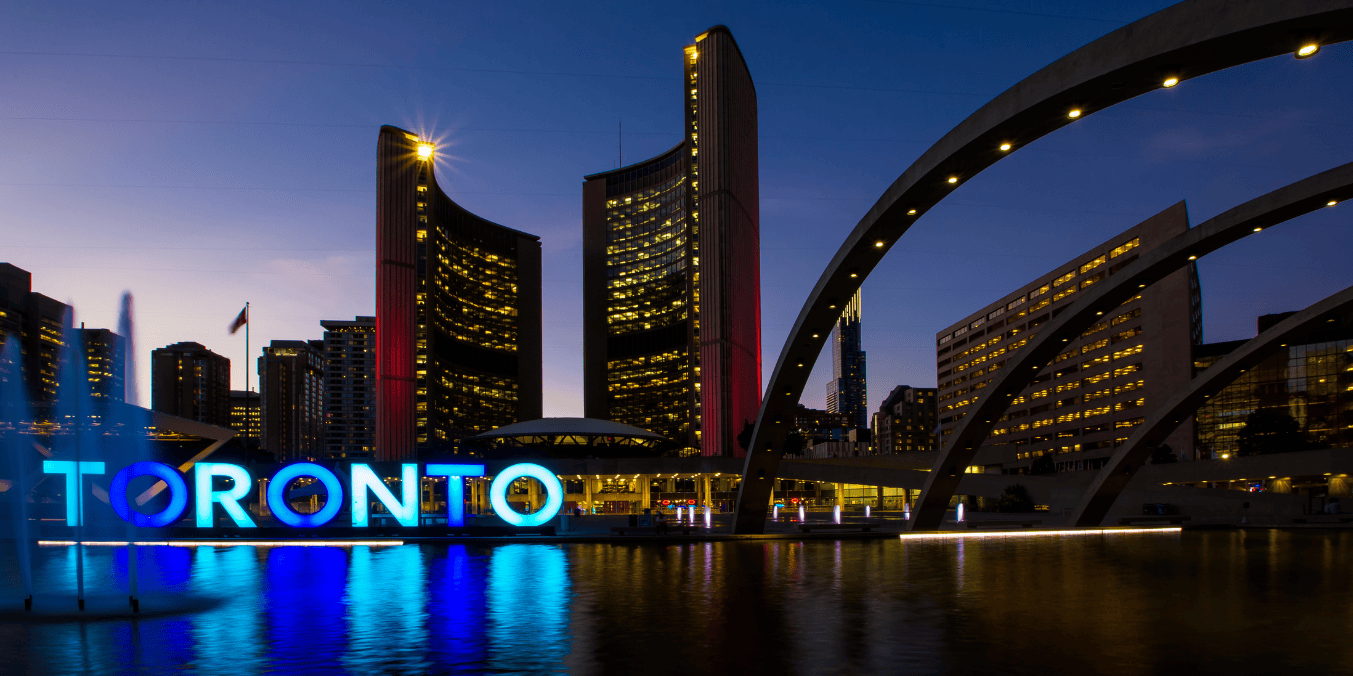 Toronto cityscape at dusk, featuring the iconic Toronto sign and skyline, representing the urban appeal when considering life in Canada vs Australia.