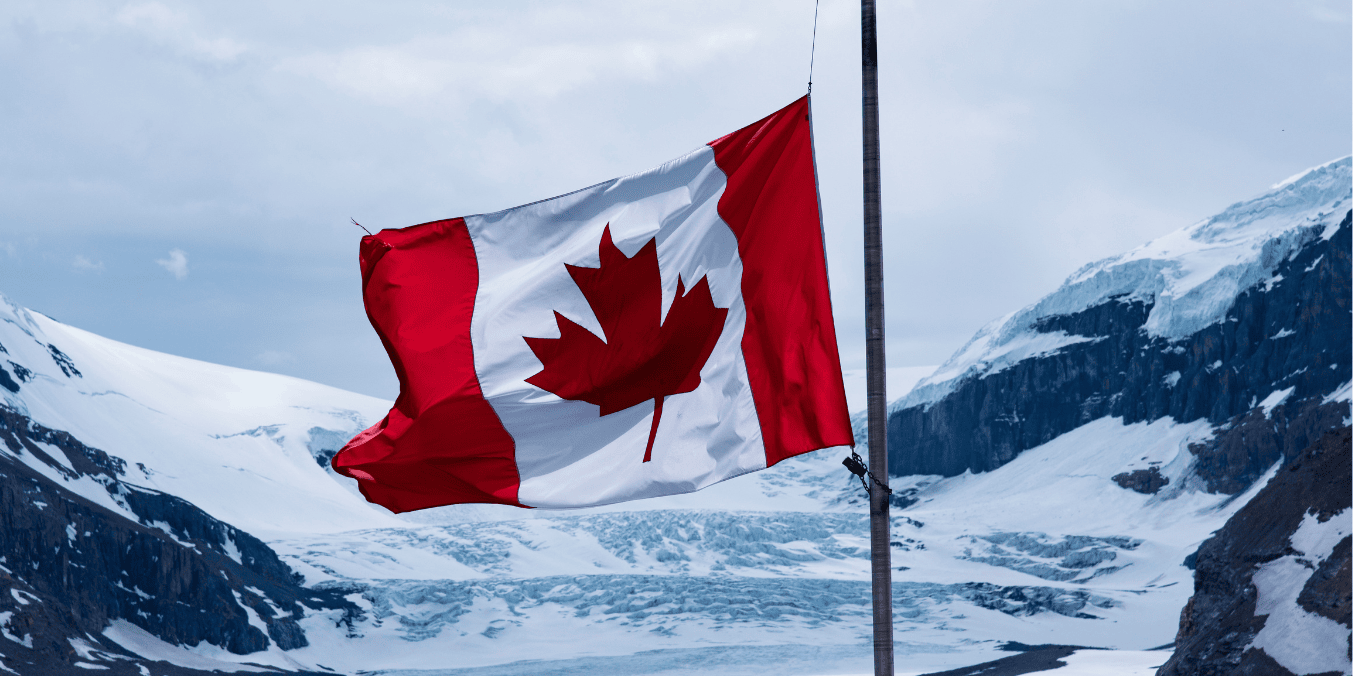 Canadian flag waving with snow-covered mountains in the background, symbolizing the scenic beauty and climate contrast in the comparison of life in Canada vs Australia.