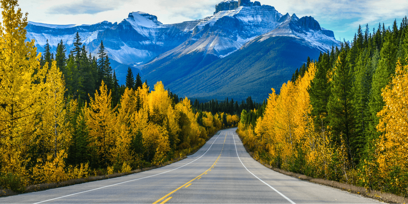 This image highlights the stunning landscapes that define life in Canada, featuring majestic mountains and vibrant autumn forests. Canada's vast natural beauty is perfect for road trips and outdoor adventures, making it a dream destination for nature enthusiasts.