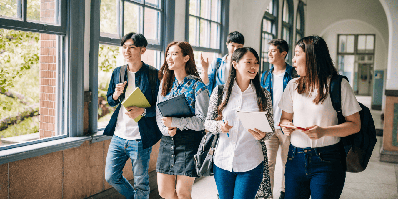 International students discussing their studies while walking through a university hallway, preparing for PGWP eligibility in Canada.