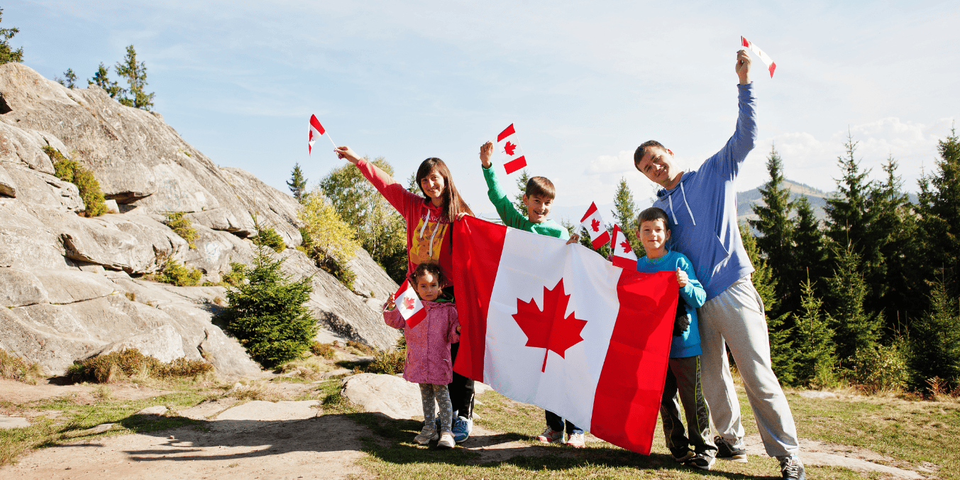 Family celebrating outdoors with Canadian flags, showcasing the advantages of Canadian citizenship.