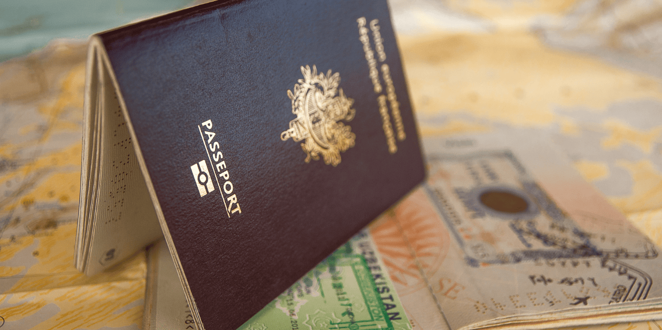 Close-up of a Canadian passport with visa stamps, resting on a map, symbolizing international travel and visa application process.