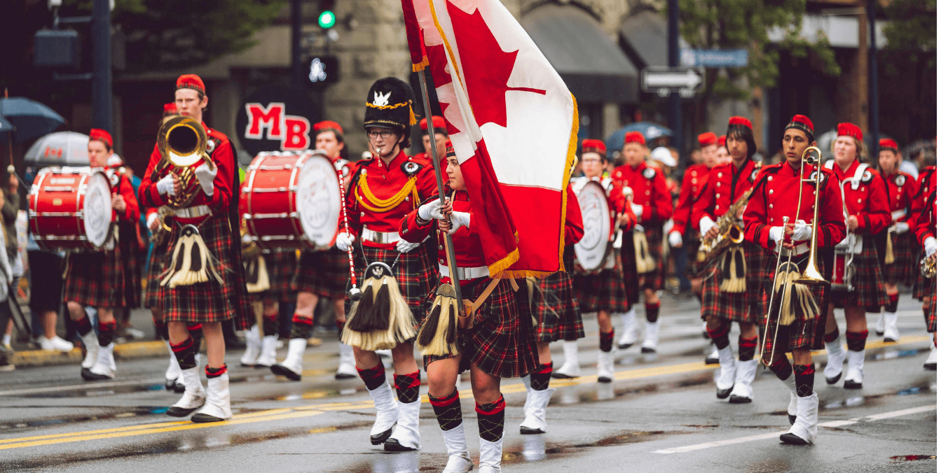 A marching band dressed in traditional red uniforms and tartan kilts parades down a rainy Canadian street, proudly displaying the Canadian flag, symbolizing the celebration of diversity and opportunities like the Express Entry Draw for immigration to Canada.