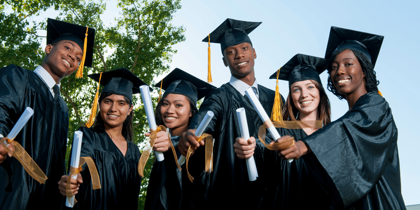 Group of diverse graduates in caps and gowns celebrating with diplomas in hand, ready to pursue their careers and meet PGWP requirements in Canada.