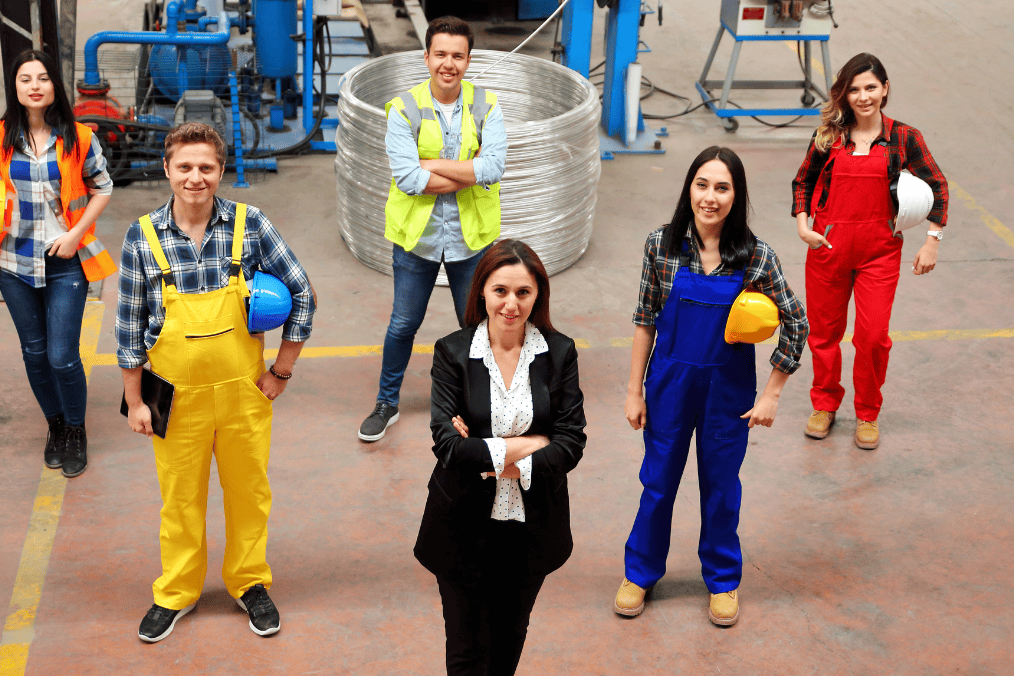 Group of Canadian factory workers and supervisor standing together, illustrating a Positive Labour Market Impact Assessment (LMIA) workforce.