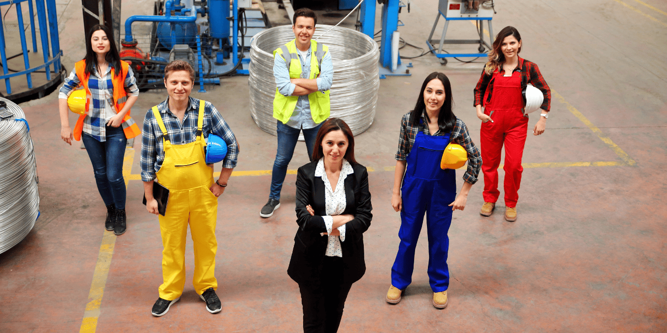 Group of Canadian factory workers and supervisor standing together, illustrating a Positive Labour Market Impact Assessment (LMIA) workforce.